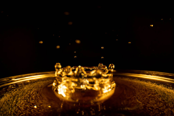 Water splash, golden water splash isolated on black background,water - Fotoğraf, Görsel