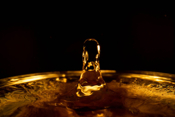 Water splash, golden water splash isolated on black background,water - 写真・画像