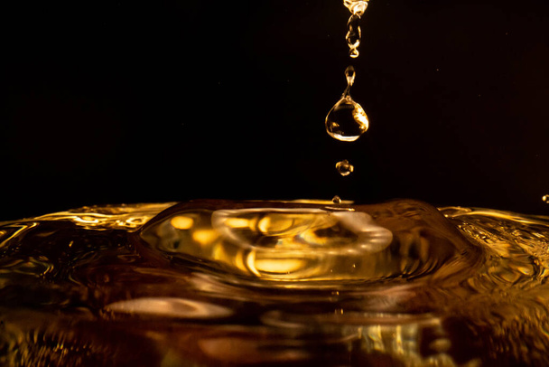 Water splash, golden water splash isolated on black background,water - Foto, imagen