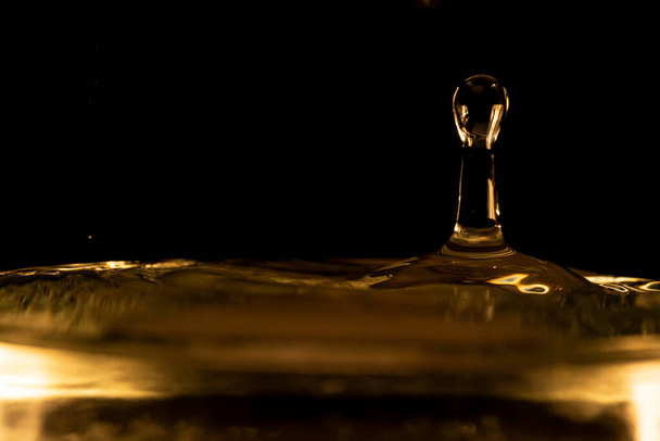 Water splash, golden water splash isolated on black background,water - Foto, Imagen