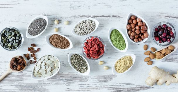 Small white bowls with various superfoods on white wooden background top view. Healthy eating concept. - Photo, Image
