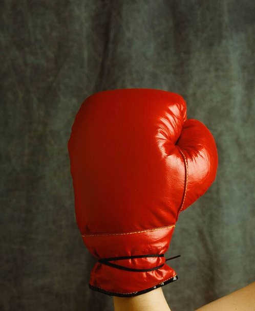 A closeup shot of a person wearing a red boxing glove - Фото, изображение