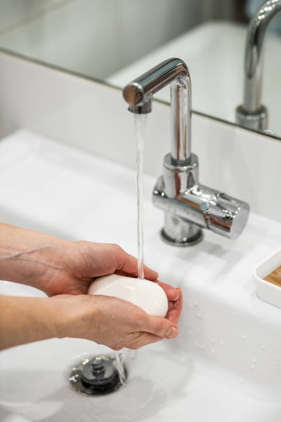 A woman washes her hands carefully with soap - Foto, immagini
