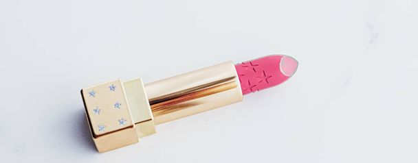 Luxus-Lippenstift in goldener Röhre auf weißem Marmorhintergrund, Make-up und Kosmetik - Foto, Bild