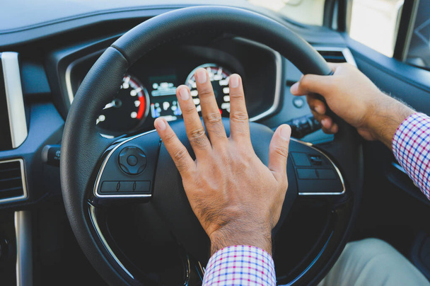Рука людини штовхає автомобільний ріг під час водіння автомобіля
. - Фото, зображення
