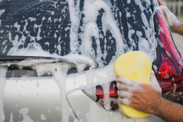 スポンジと泡で車を洗浄男 - 写真・画像