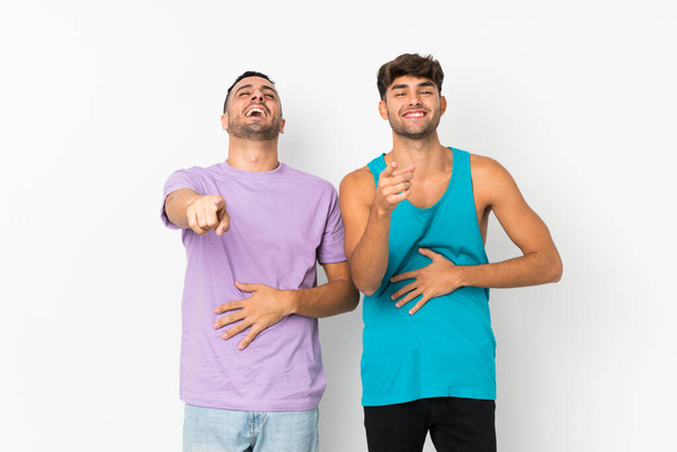 Zwei Männer mit isoliertem Hintergrund zeigen mit dem Finger auf jemanden und lachen viel - Foto, Bild