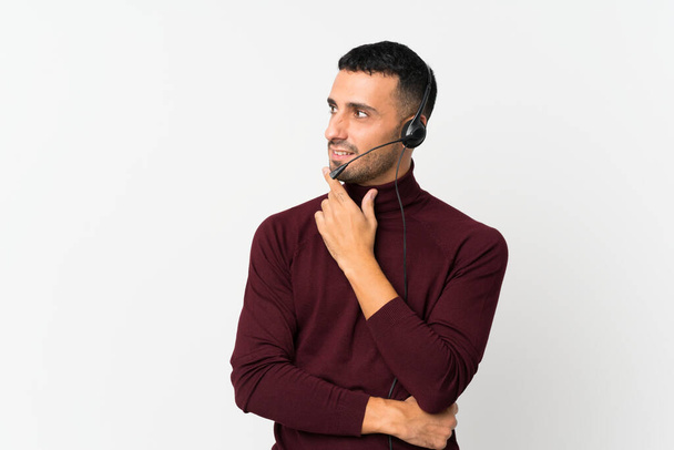 Young man over isolated white background working with headset - Photo, Image