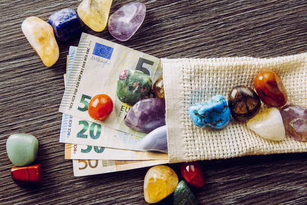 Sok különböző színű és típusú féldrágakő europénz bankjegyekkel. Drága hobbi kőgyűjtő koncepció. - Fotó, kép