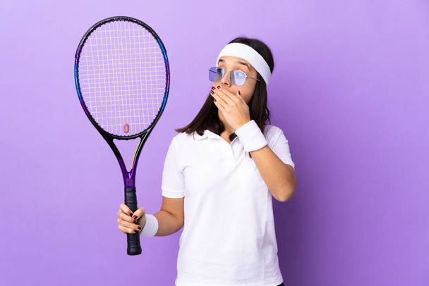 Молода жінка тенісистка над ізольованим тлом робить несподіваний жест, дивлячись в бік
 - Фото, зображення