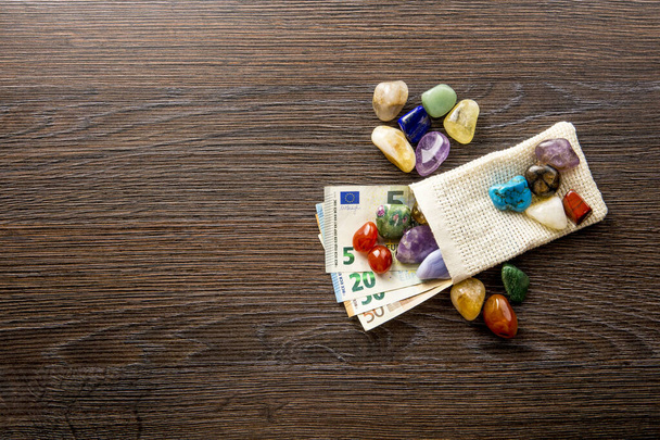 Багато різних кольорових і типових напівдорогоцінних каменів з банкнотами євро. Дороге хобі концепція колекціонування каменю
. - Фото, зображення