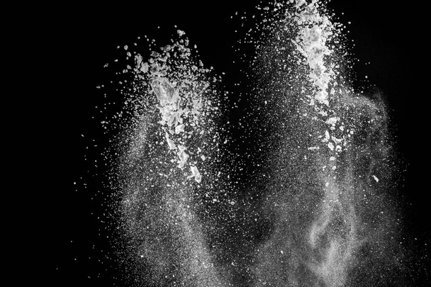 Platzen von weißem Pulver mit Mehl und Zucker schafft ein schönes Muster isoliert auf schwarzem Hintergrund 2020 - Foto, Bild