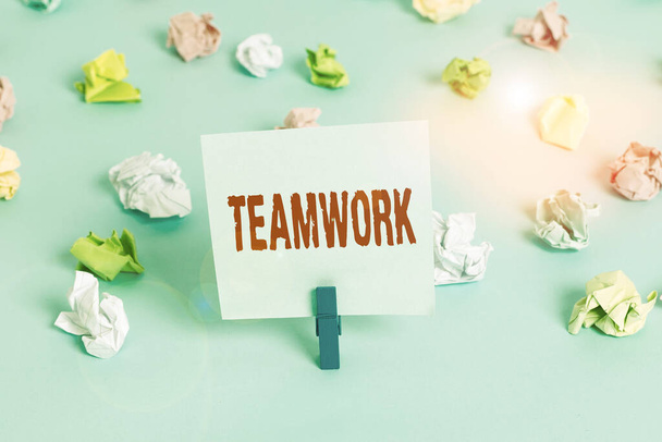 Text sign showing Teamwork. Conceptual photo combined action of group especially when effective and efficient Colored crumpled papers empty reminder blue floor background clothespin. - Photo, Image