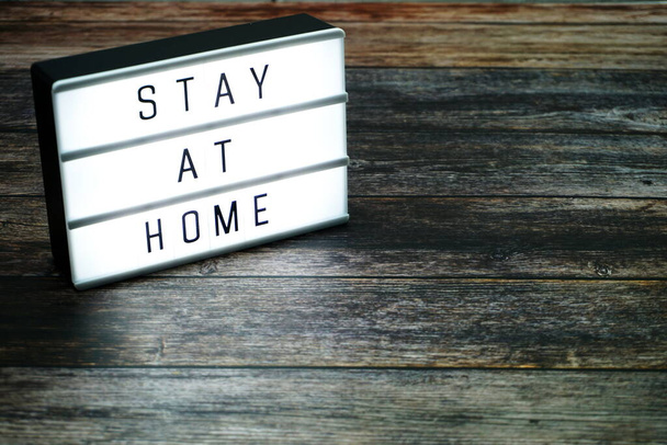 Stay at Home word letter in light box on wooden background - Foto, Imagem