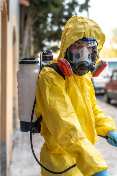 Coronavirus. A sanitation worker wearing a mask and cleaning the streets. Sterilize urban decontaminate city. Disinfecting against to the Coronavirus. Suit protection.  - Fotografie, Obrázek