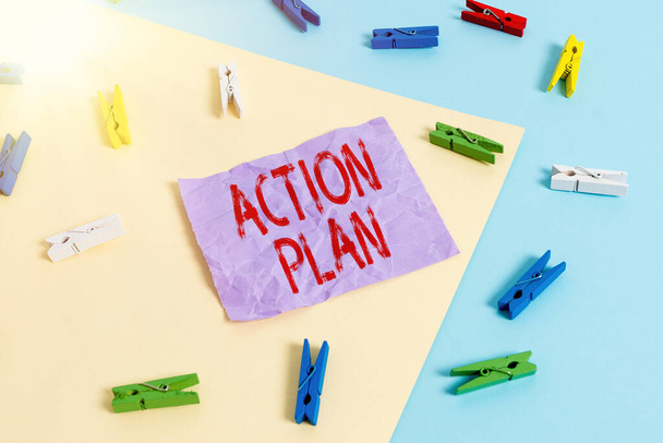 Text sign showing Action Plan. Conceptual photo proposed strategy or course of actions for certain time Colored clothespin paper empty reminder yellow blue floor background office. - Photo, Image