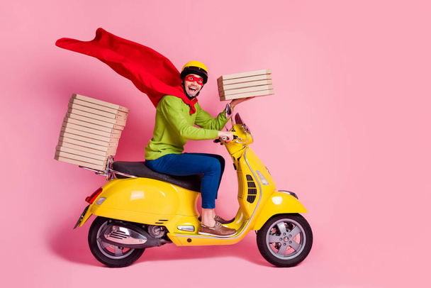 Profile side view of his he nice attractive funky cheerful cheery ecstatic guy driving moped fast speed wearing cape service order client hurry rush isolated over pink pastel color background - Foto, imagen