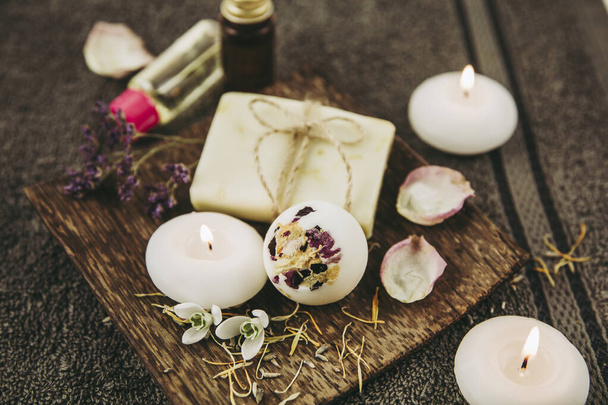 Various relaxation bath products on natural wood tray: creamy bath bomb, bar of soap and aroma oil bottles. Cozy relaxation at home concept. - Valokuva, kuva