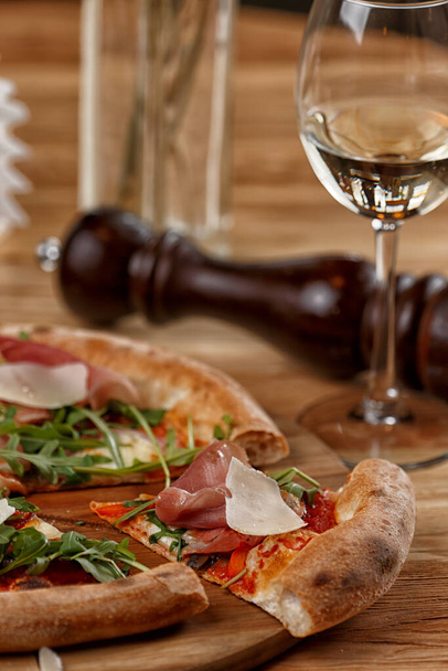 pizza with jamon and herbs on a wooden table - 写真・画像