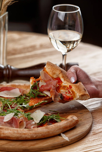 pizza with jamon and herbs on a wooden table - Photo, Image