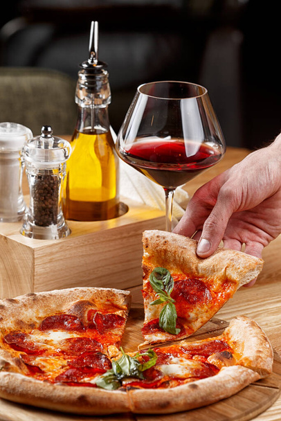pizza pepperoni et un verre de vin sur une table en bois
 - Photo, image