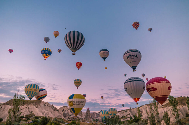 Kapadokya Türkiye tepelerde sıcak hava balonlarıyla, Kapadokya 'da gün doğumunda Kapadokya' da güneş ışığı altında güzel renkli balonlar. - Fotoğraf, Görsel