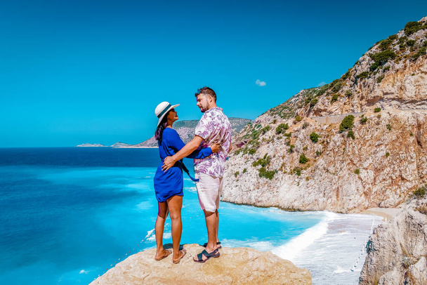 pareja de vacaciones Turquía, Kaputas Beach Kas pavo, blanco naranja playa de acantilados junto al océano de Kas Turquía rivera, hombres y mujeres de pie en el acantilado mirando océano
 - Foto, imagen