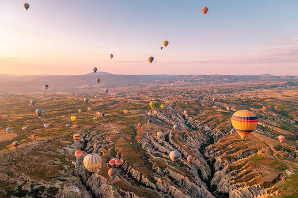 Cappadocia Törökország napkelte a hegyekben hőlégballonokkal, Kapadokya Gyönyörű élénk színes lufik napsütésben Cappadocia Törökország Goreme - Fotó, kép