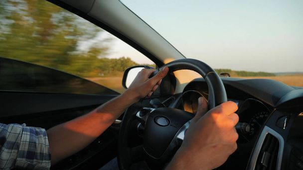 Closeup of man hands on steering wheel driving car - Photo, Image