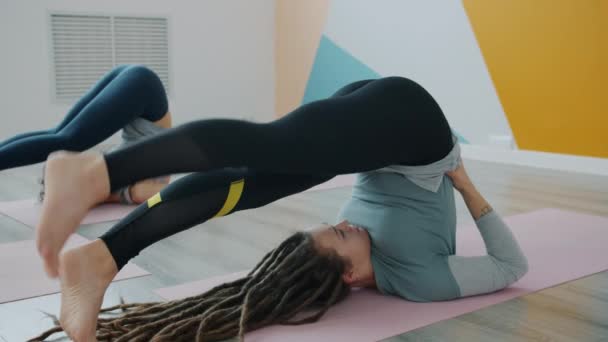 Flexible young people practiising reverse yoga position on mats in modern sports center - Filmagem, Vídeo