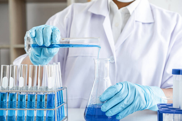 Biochimie recherche en laboratoire, Chimiste analyse l'échantillon en laboratoire avec des équipements et des expériences scientifiques verrerie contenant liquide chimique. - Photo, image