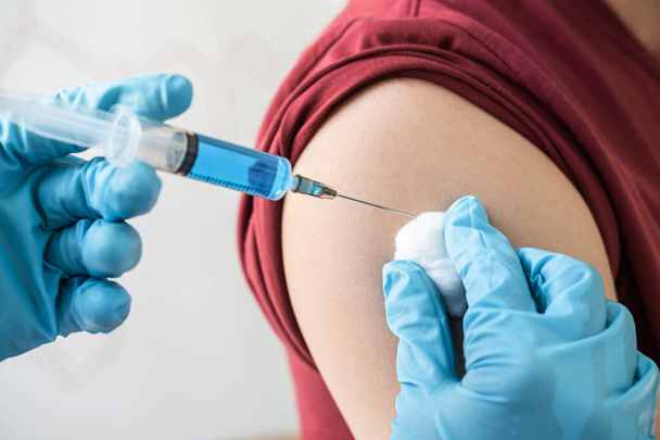 Doctor making injection vaccination patient to prevent pandemic of the disease, flu or influenza virus in clinic. - Photo, Image