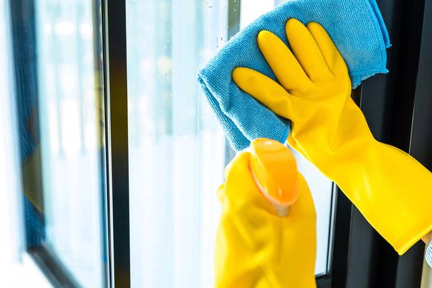 Wife housekeeping and cleaning concept, Happy young woman wiping dust using a spray and a duster while cleaning in glass at home. - Foto, Bild