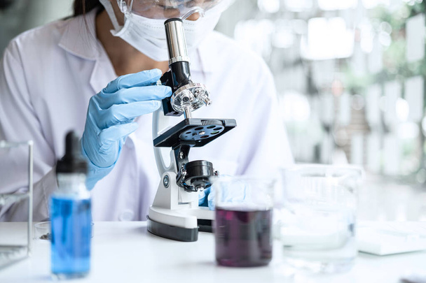 Biochemie Laborforschung, Chemiker analysiert Probe im Labor mit Mikroskopausrüstung und wissenschaftlichen Experimenten Gläser mit chemischer Flüssigkeit. - Foto, Bild