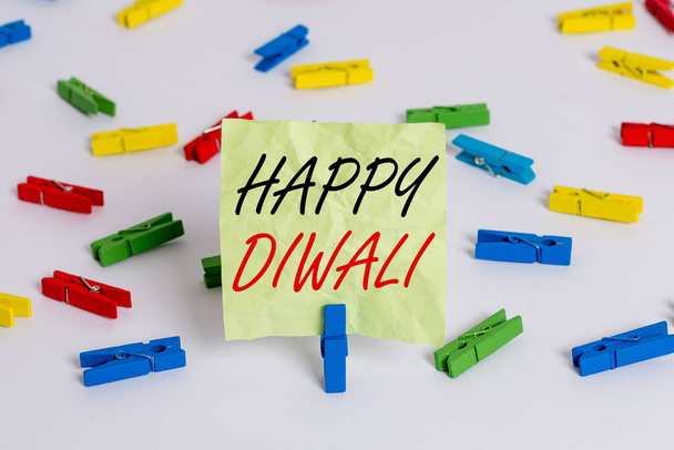 Schrijfbriefje met Happy Diwali. Zakelijke foto presentatie festival van lichten die gevierd door miljoenen hindoes gekleurde wasknijpers lege herinnering witte vloer achtergrond kantoor. - Foto, afbeelding