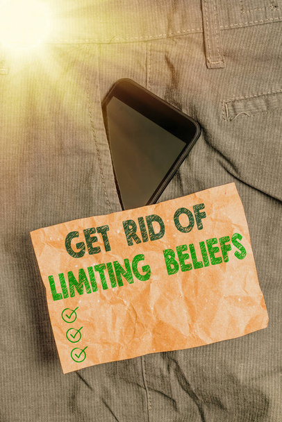 Schrijfbriefje met Get Rid Of Limiting Beliefs. Zakelijke foto presentatie verwijder negatieve overtuigingen en denk positief Smartphone apparaat in broek voor pocket note papier. - Foto, afbeelding