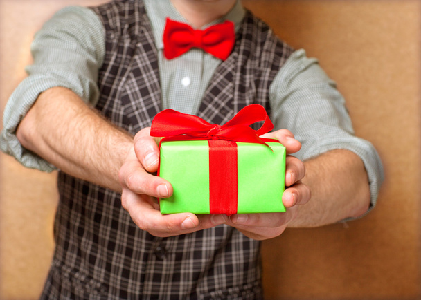 male hands holding small gift with ribbon. - Φωτογραφία, εικόνα