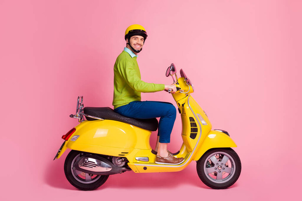 Profile side view portrait of his he nice attractive confident glad cheerful cheery guy riding moped traveling transport vehicle move isolated over pink pastel color background - Foto, Bild