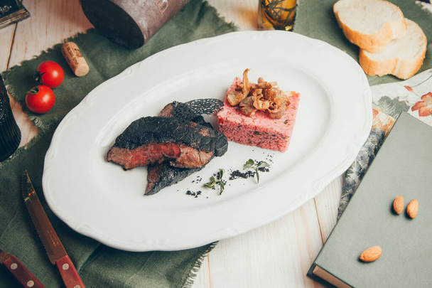Restaurant serviert Steak auf einem Teller mit Pfeffer. Mittleres seltenes Steak mit Reis.  - Foto, Bild