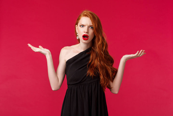 Fashion, luxury and beauty concept. Portrait of arrogant and frustrated young pretty redhead woman complaining on restaurant waiters, shrugging with hands spread sideways dismay, look annoyed - Φωτογραφία, εικόνα