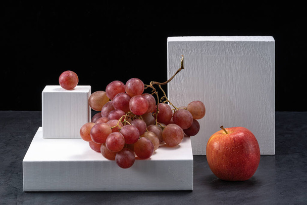 Bunches of green and red grapes with apple on a dark background. - Foto, afbeelding