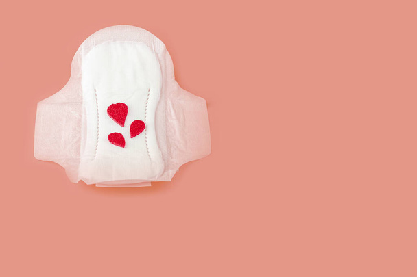 Protective menstrual pad with fabric blood drops on orange background. The concept of women gynecological health and intimate hygiene. Copy space for text, close u - Foto, Imagen