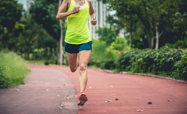 Fitness mujer deportiva corriendo al aire libre trotando pista en el parque
 - Foto, Imagen