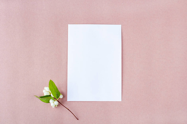 Invitation card mockup. Template blank greeting card to the wedding, birthday and other events. Paper on pink background with white flowers. Concept of writing romantic  for Valentines day - Fotoğraf, Görsel