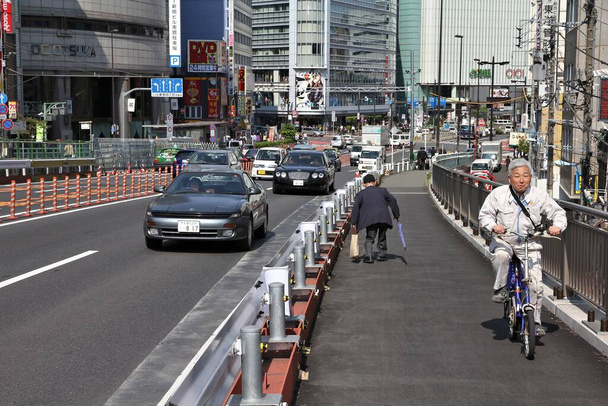 TOKYO, JAPAN - MAY 11, 2012: People visit Shinjuku district, Tokyo. Shinjuku is one of the busiest districts of Tokyo, with many international corporate headquarters located here. - 写真・画像