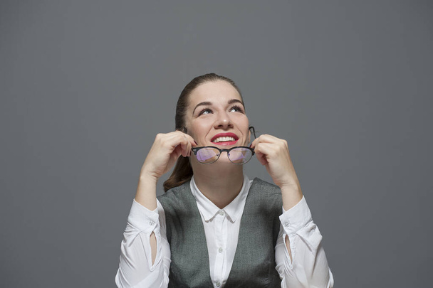 Businesswoman holds eyeglasses smiling - Fotó, kép