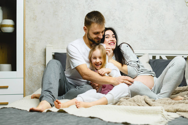 Ölelés fiatal boldog család otthon - Fotó, kép