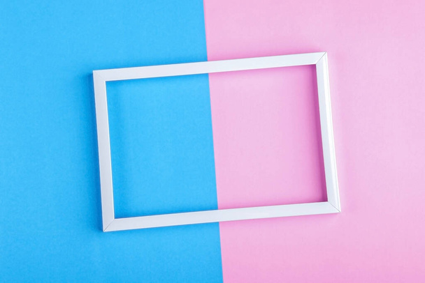 Empty white frame on a duotone background (blue, pink) with copy space for text or lettering. Minimal geometric lines composition. Top view, flat lay, mock up. - Фото, изображение