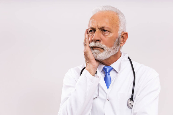 Image of worried  senior doctor thinking on gray background. - Fotografie, Obrázek