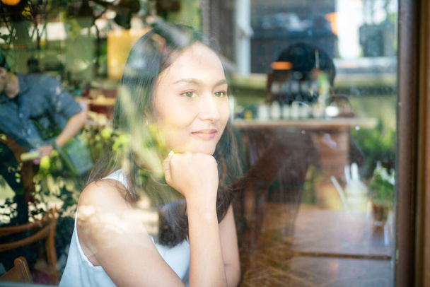 Belles femmes asiatiques assises dans un café urbain regardant par la fenêtre, Femmes d'affaires - Photo, image